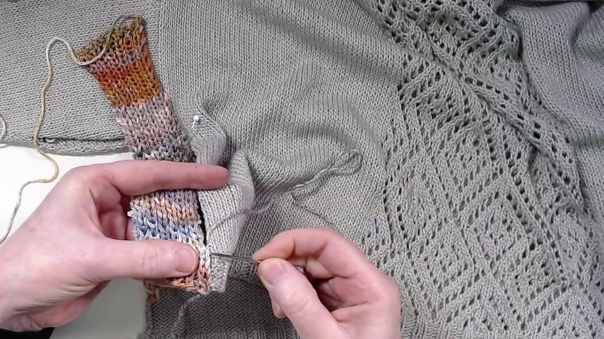 Ein gestreifter Kontraststreifen wird in die Seitennaht eines Pullovers genäht