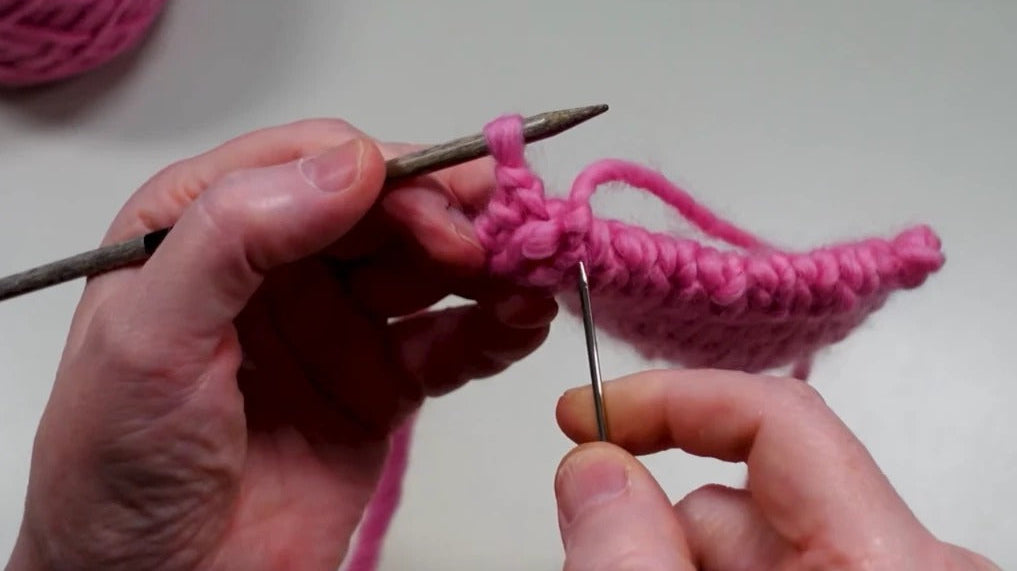 Wollnadel beim italienischen Abketten an einem pinkfarbenen 1x1-Rippenbündchen