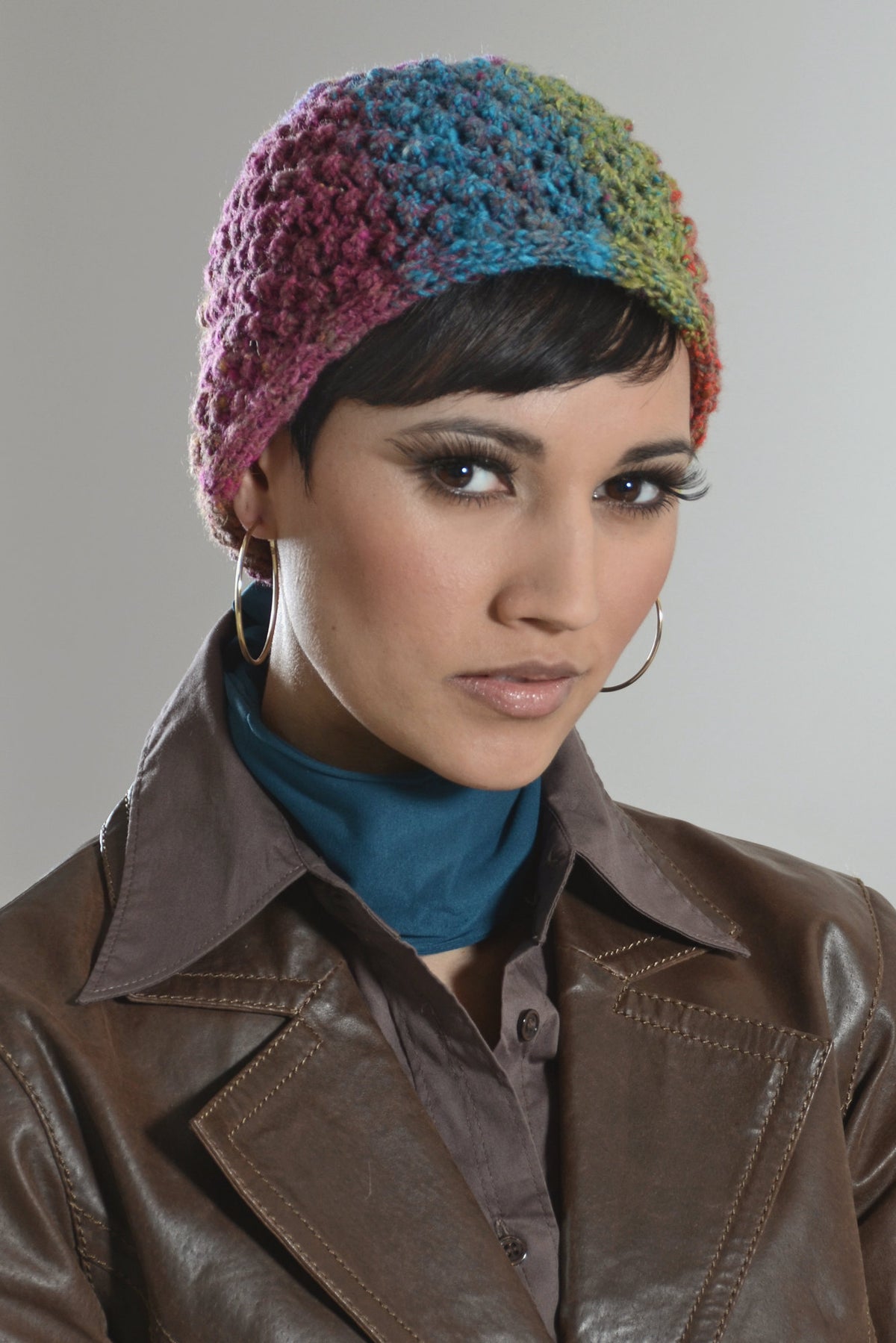 Mütze Calista aus buntem Verlaufsgarn mit quer gestricktem Musterband im Brombeermuster.