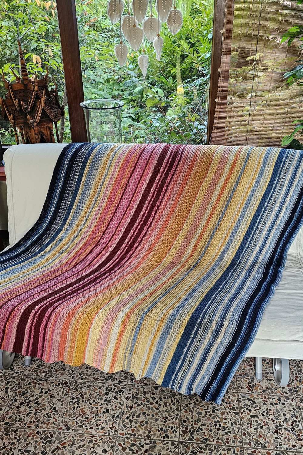 Jahresdecke, Strickanleitung, gestreifte Temperaturdecke kraus rechts über einem Sofa