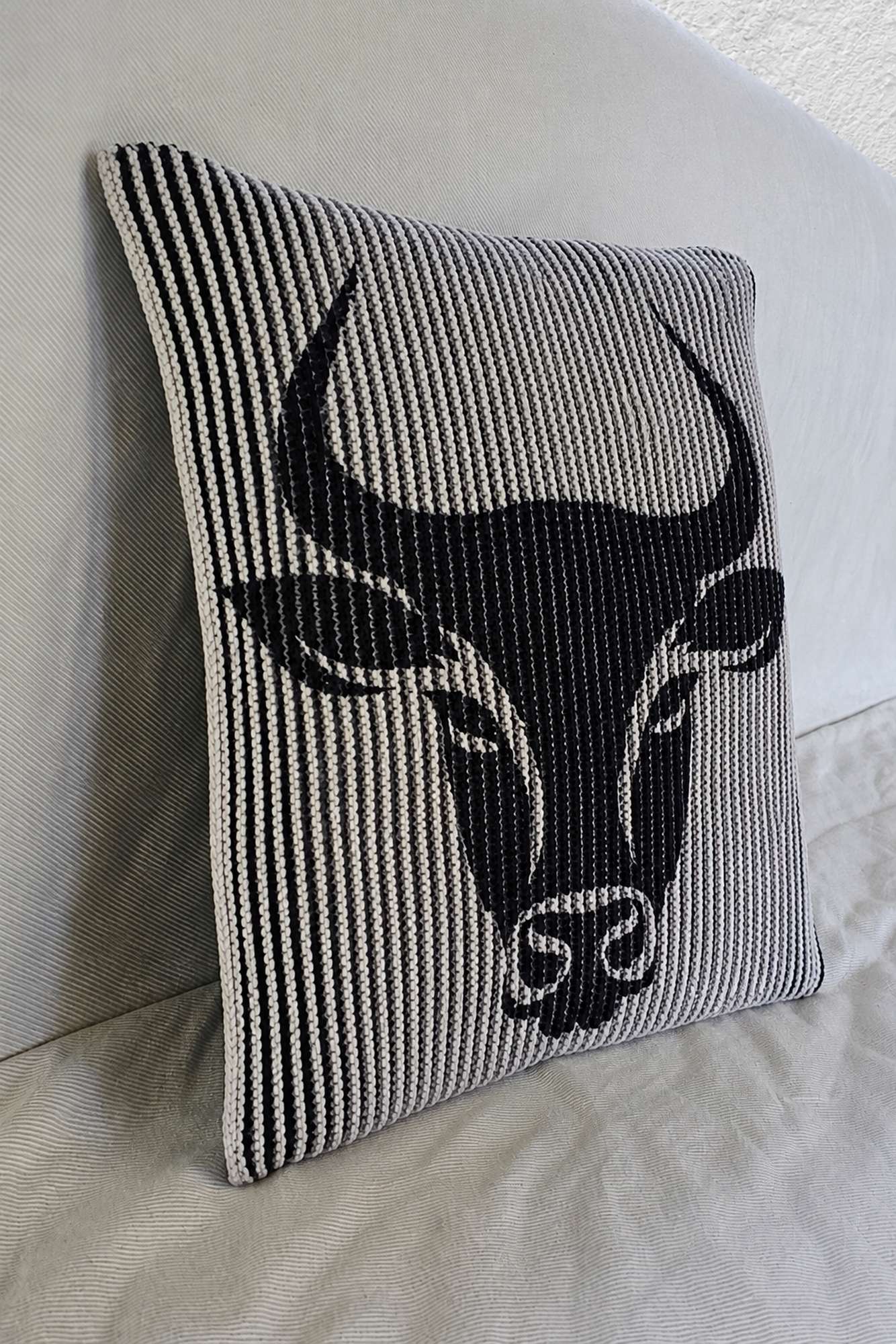 Schattenstrick-Kissen mit dem Motiv Taurus, Sternzeichen Stier, zweifarbig gestrickt