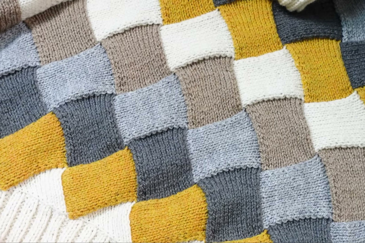 Fünffarbiges Entrelac-Muster am flach liegenden Pullover Taken