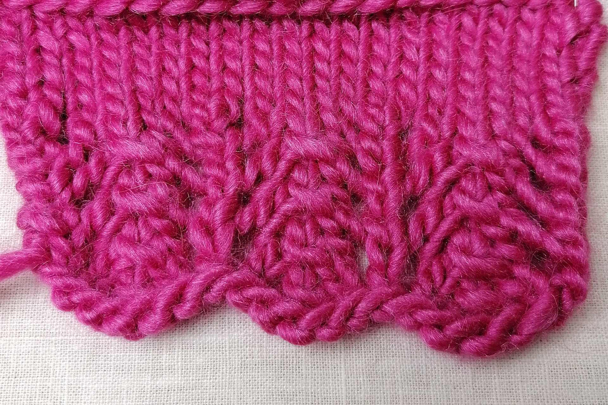 Gestrickte Zickzackkante mit Lochmuster in Rosa