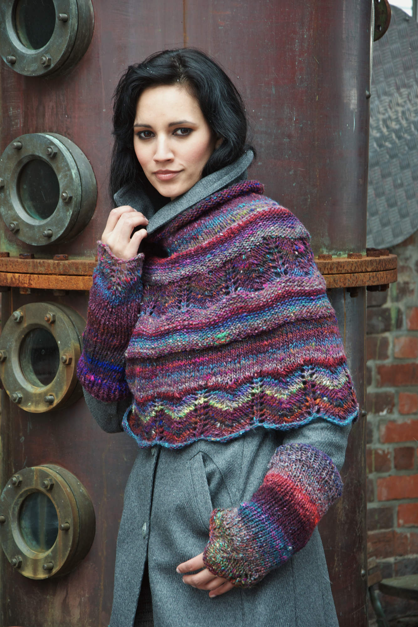 Poncho und Pulswärmer Iced Blackberry aus buntem Verlaufsgarn mit gestrickter Bortenkante.