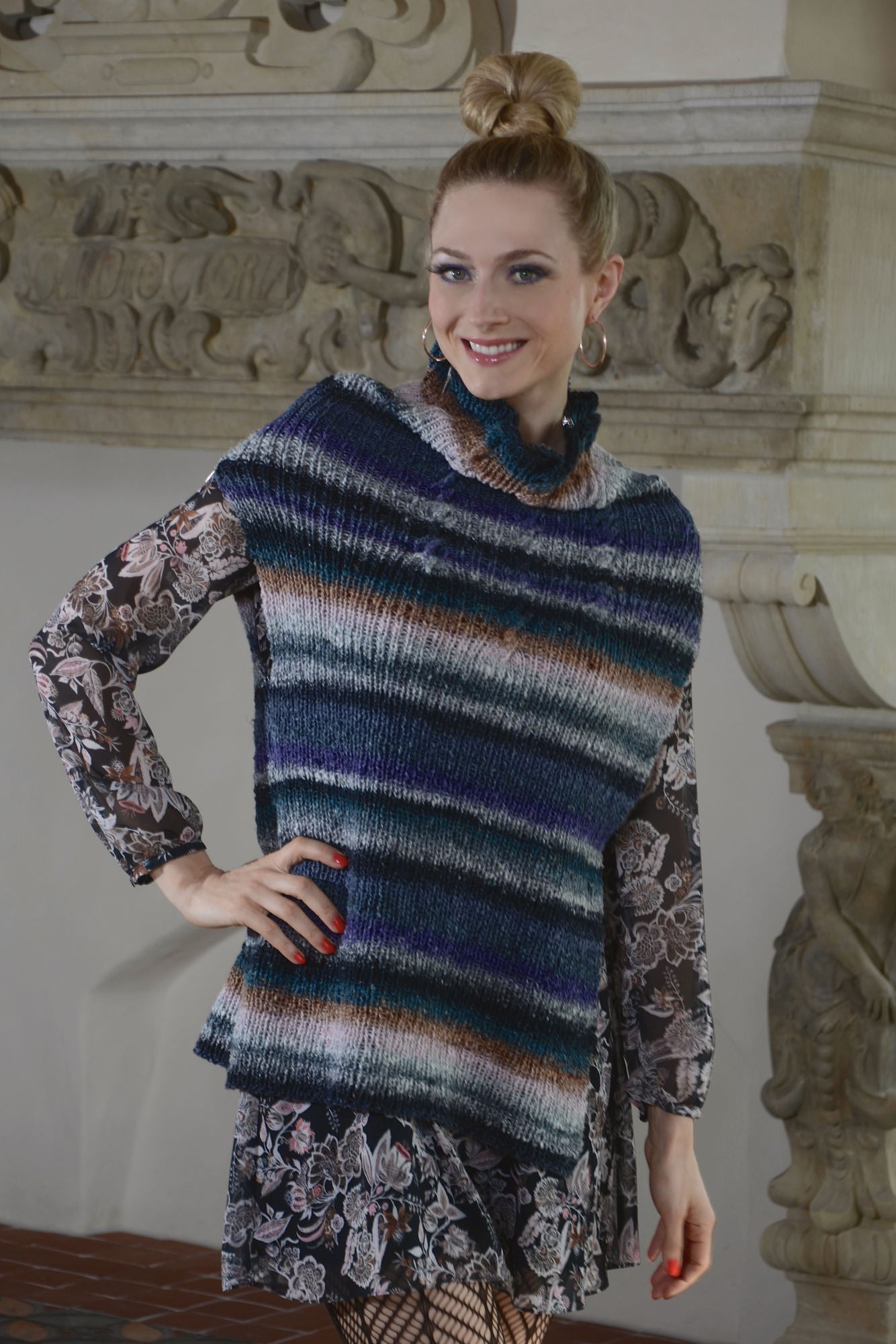 Asymmetrischer Poncho Sansa aus buntem Verlaufsgarn im Rippenmuster mit Zopf.