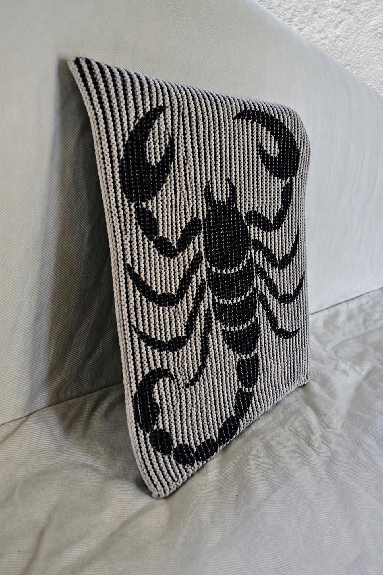 Schattenstrick-Kissen mit dem Motiv Scorpio, Sternzeichen Skorpion, zweifarbig gestrickt
